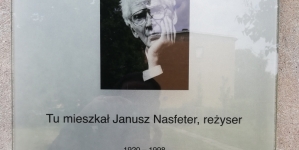 Tablica informacyjna na ścianie bloku w którym mieszkał Janusz Nasfeter.